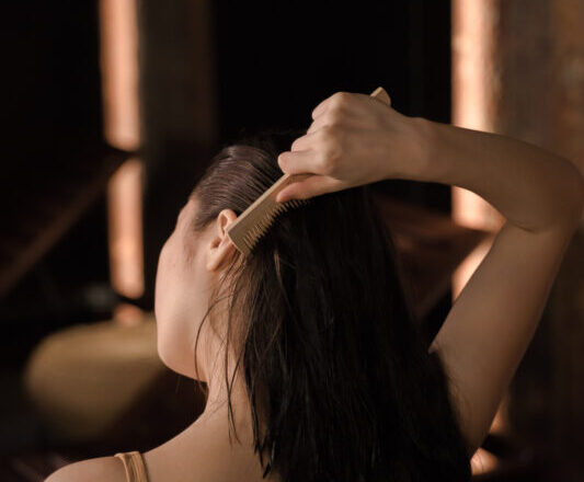 Back view of woman combing her hair